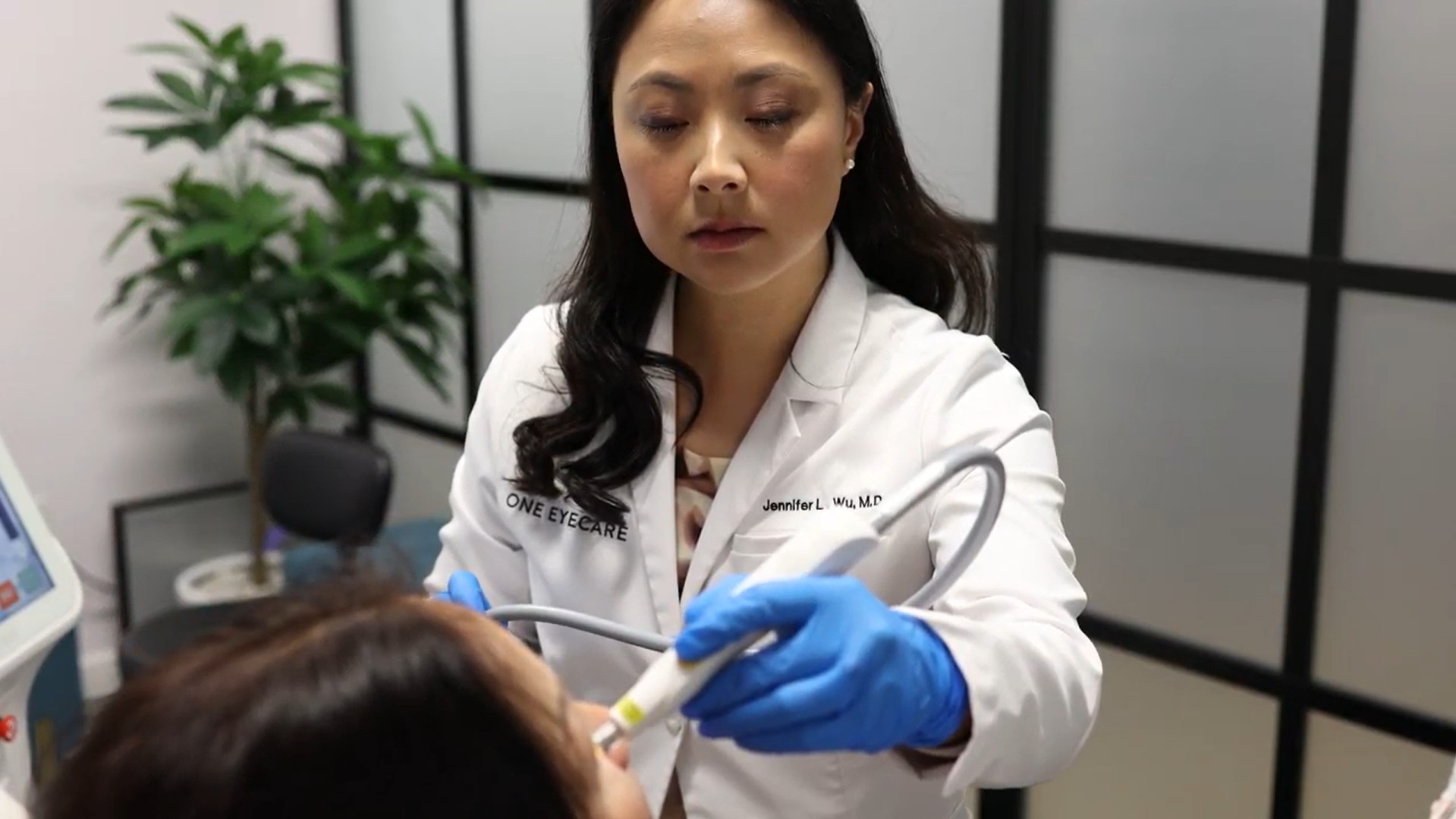 Dr. Jennifer Wu performing an eye procedure on a patient in a modern exam room – Ophthalmologist Costa Mesa