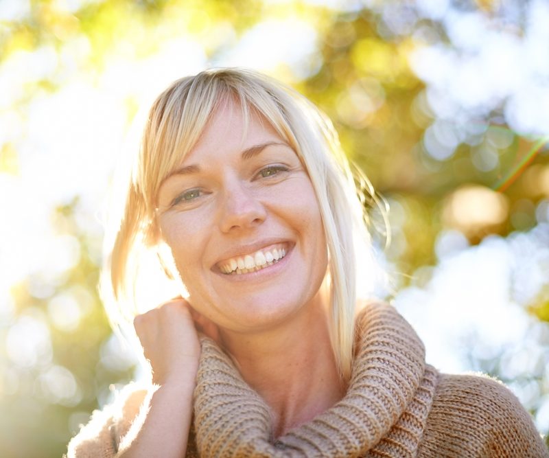 Smiling woman outdoors representing improved visual clarity and quality of life after advanced vision correction for evo icl keratoconus – evo icl keratoconus
