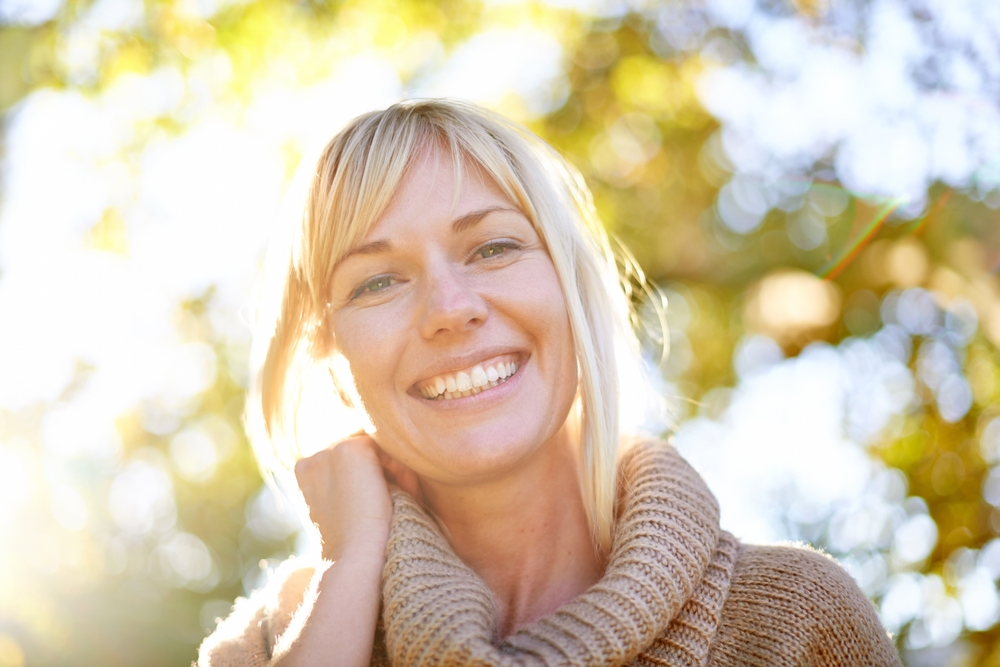 Smiling woman outdoors representing improved visual clarity and quality of life after advanced vision correction for evo icl keratoconus – evo icl keratoconus