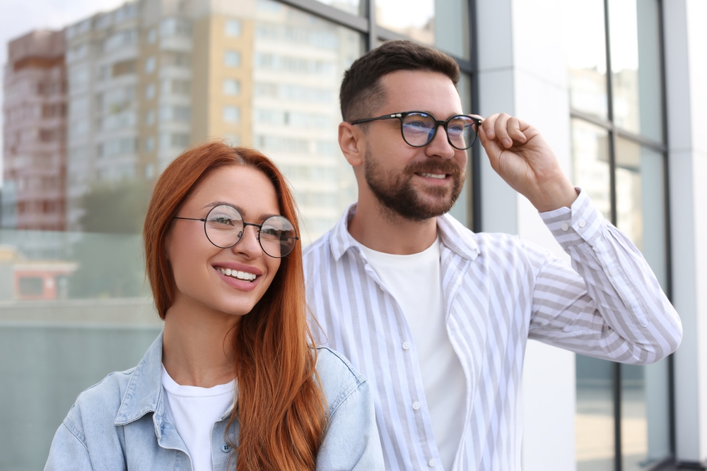 Smiling man and woman experiencing improved eyesight and visual freedom following implantable lens treatment – EVO ICL Procedure