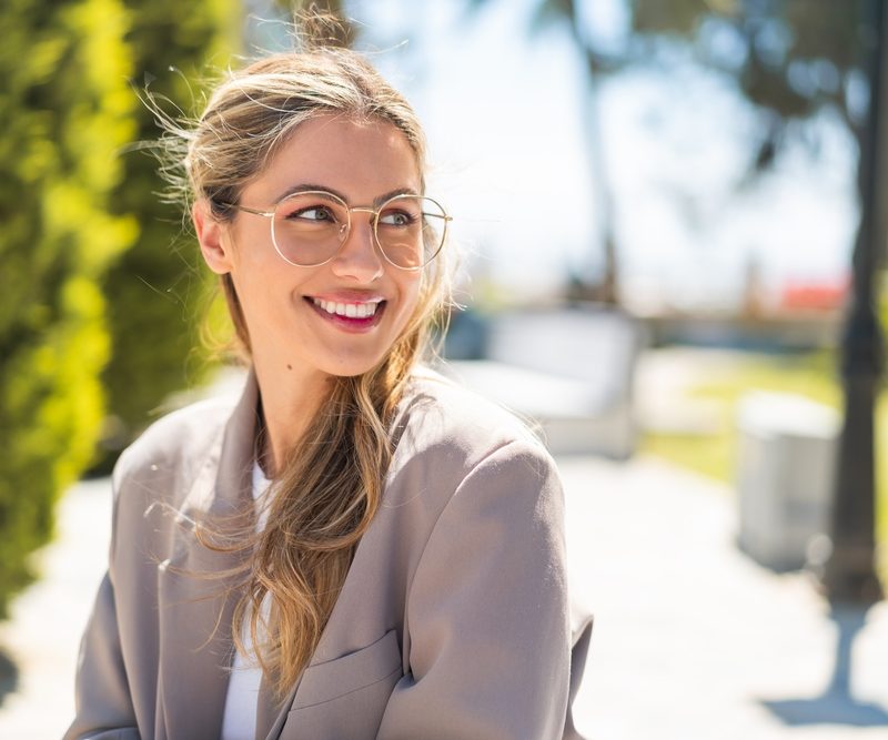 Woman wearing glasses smiling outdoors while experiencing vision changes and wondering how do i know when i need cataract surgery – how do i know when i need cataract surgery