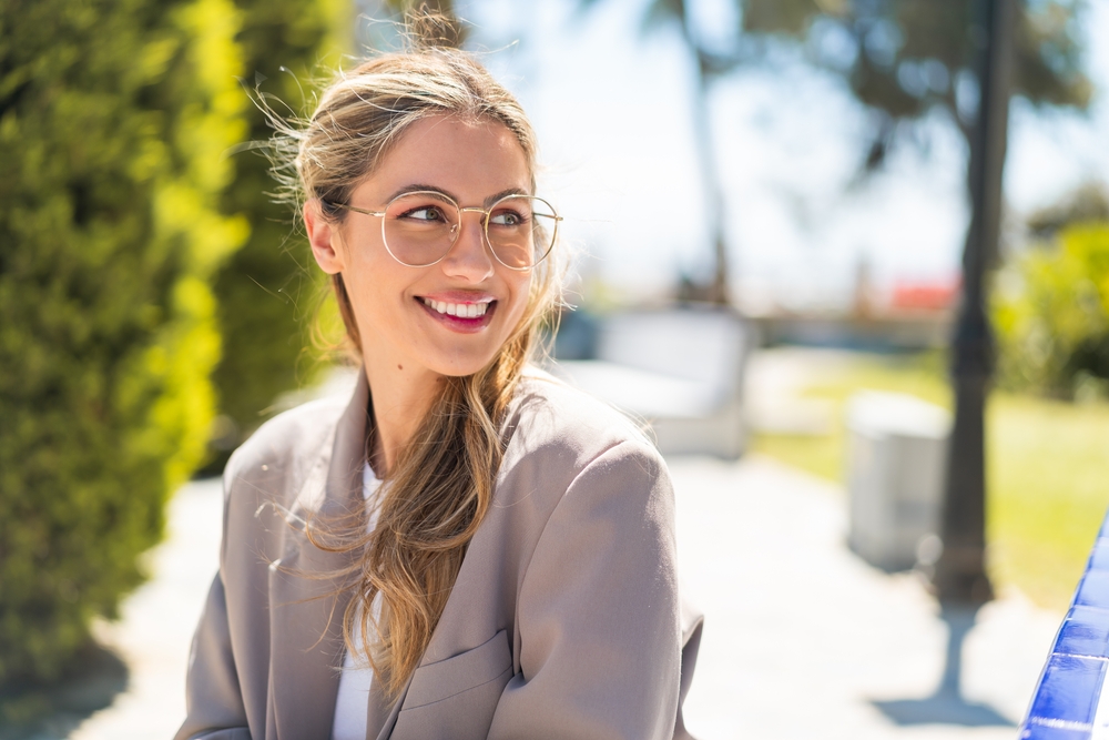Woman wearing glasses smiling outdoors while experiencing vision changes and wondering how do i know when i need cataract surgery – how do i know when i need cataract surgery